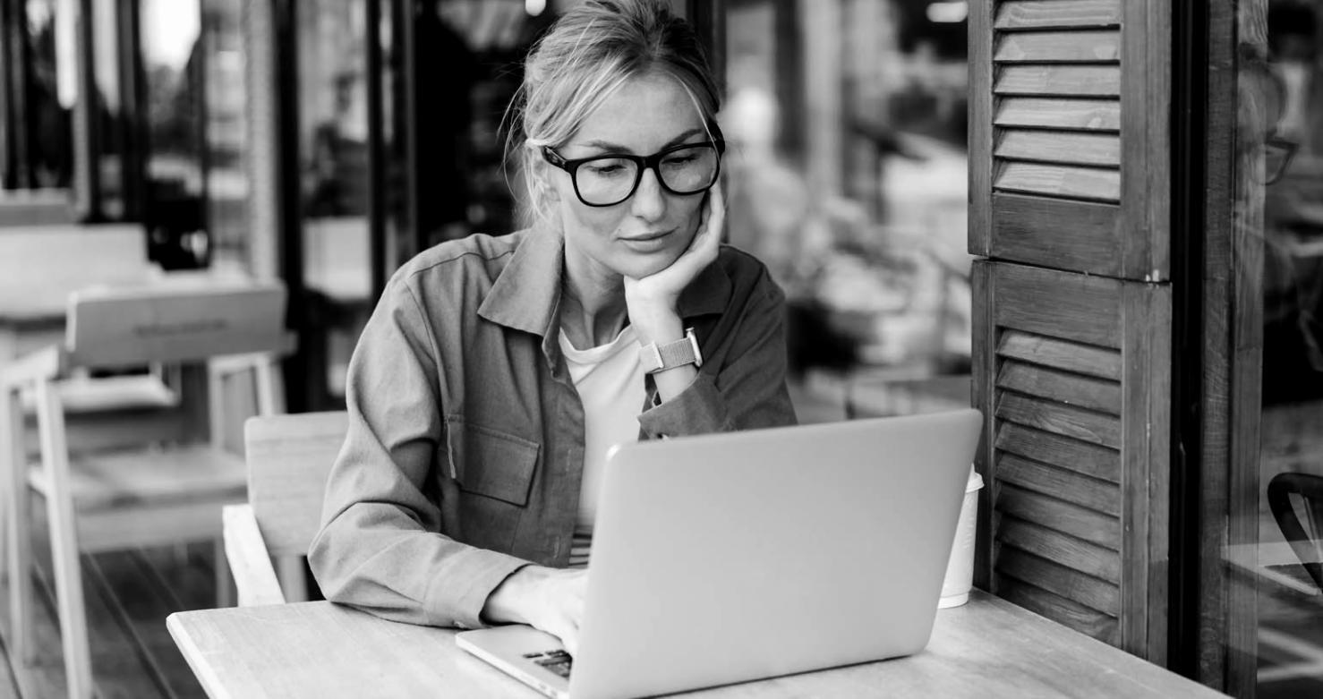 Bureau moderne avec écrans multiples affichant tableaux de bord d'investissement et analytics en temps réel